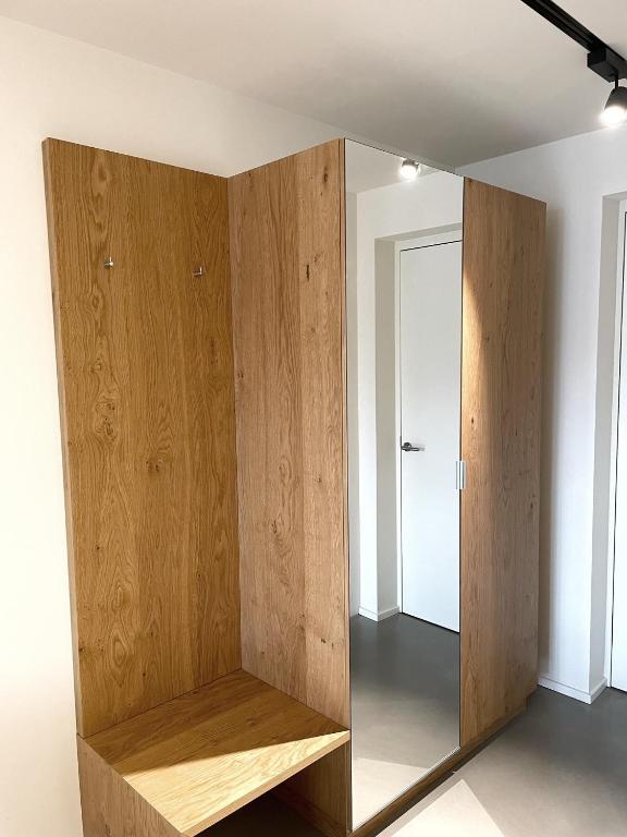 a large wooden cabinet in a room with a mirror at Apartmenthaus Anna in Lustenau