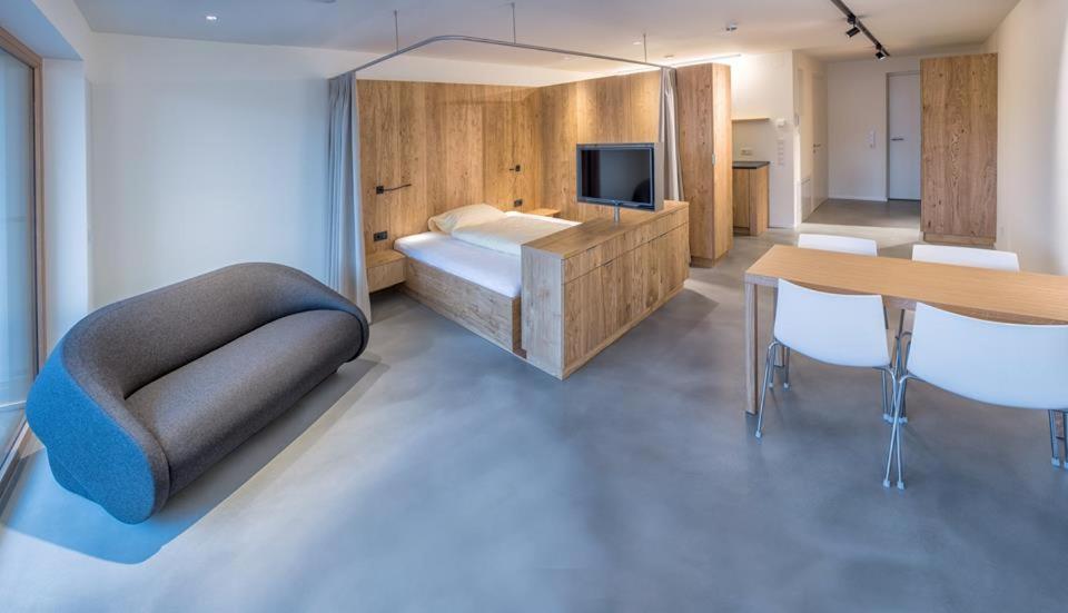 Schlafzimmer mit einem Bett, einem Tisch und einem TV in der Unterkunft Apartmenthaus Anna in Lustenau