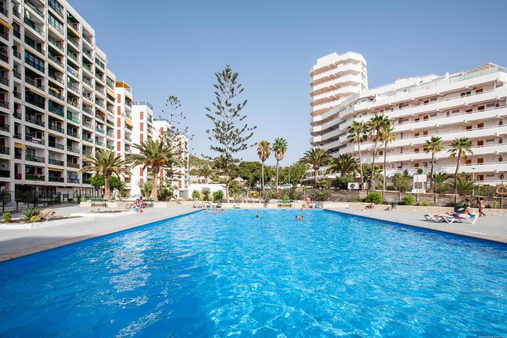 a large swimming pool in a city with buildings at Las Americas de LUX 98m2 in Playa Fañabe