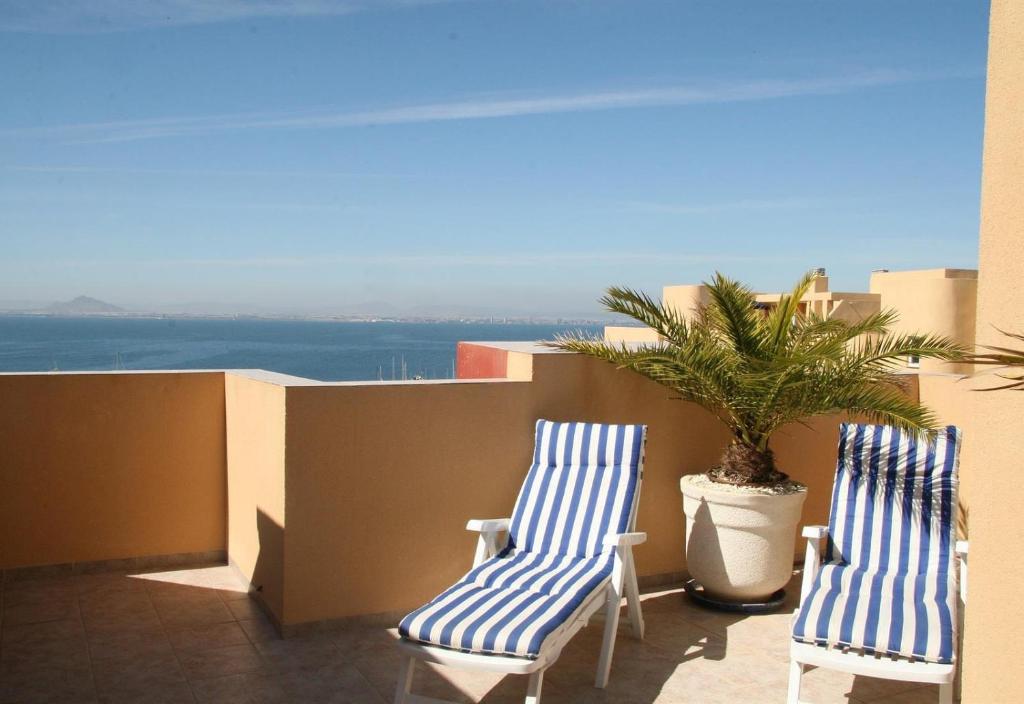 2 sillas azules y blancas en un balcón con una planta en Luxury Penthouse with Seaview, en La Manga del Mar Menor