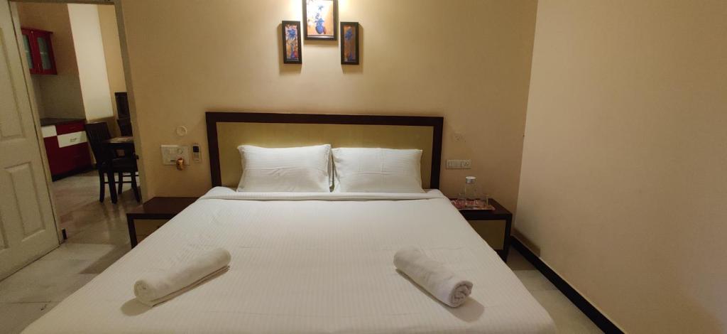 a bedroom with a bed with two towels on it at Coral Shelters Keelavasal in Madurai