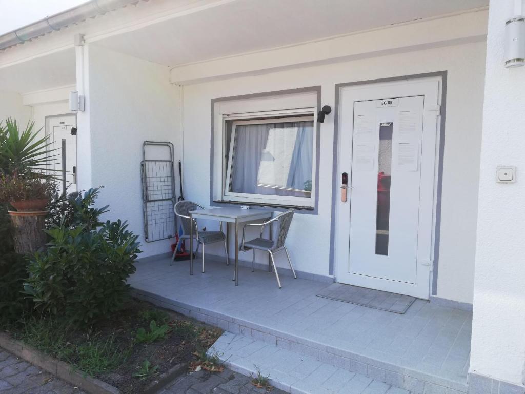 un patio con mesa y sillas junto a una puerta en Apartment-EG-05, en Darmstadt