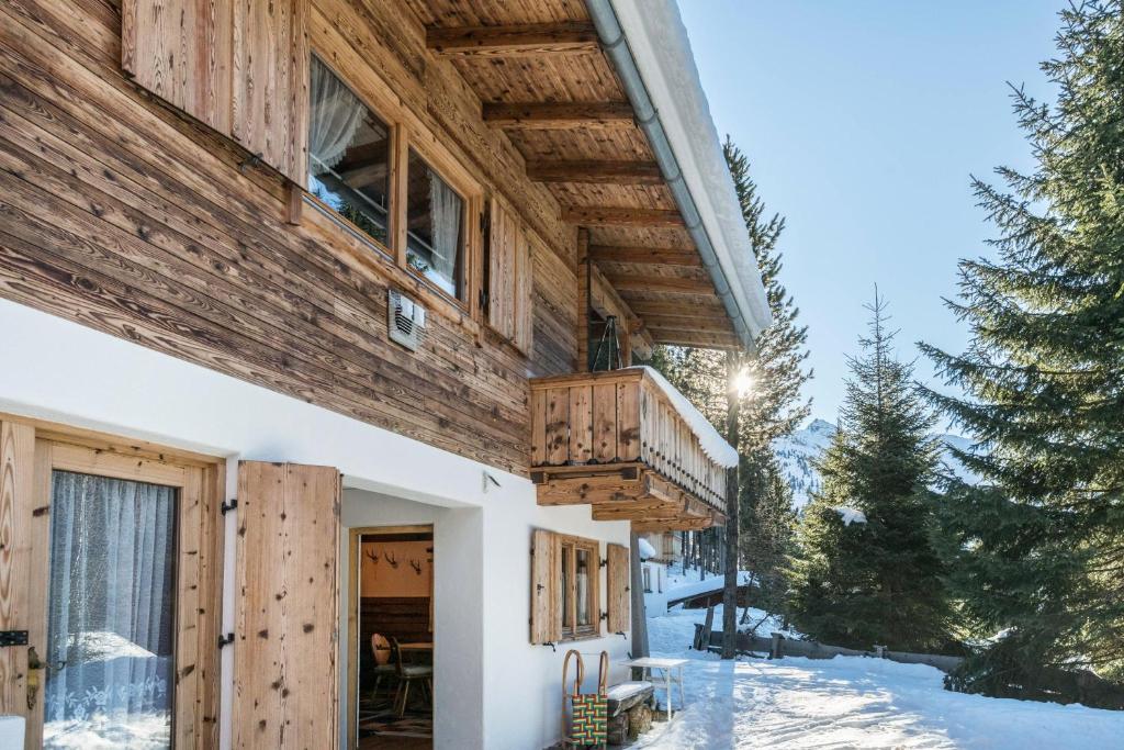 uma casa na neve com uma varanda em Hochfügenblick-ski- und Wanderhütte em Hochfugen