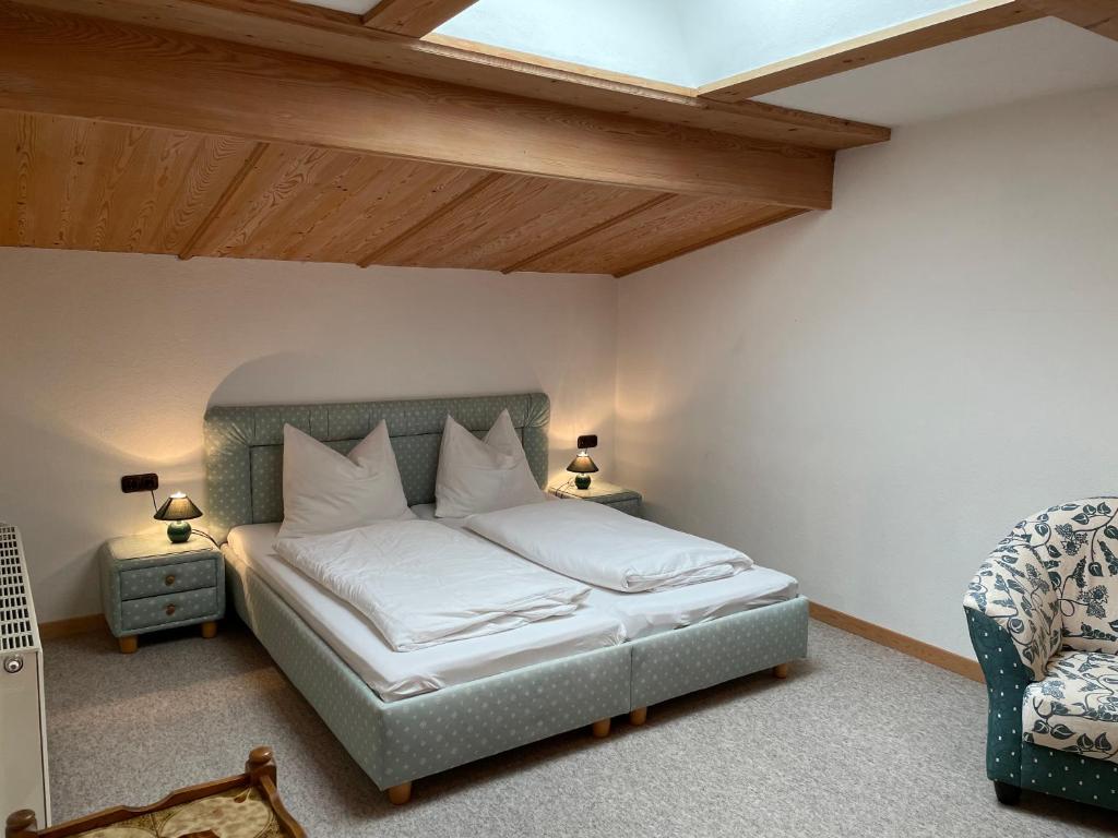 a bedroom with a bed with white sheets and a skylight at Appartement Oberlacken in Sankt Johann in Tirol
