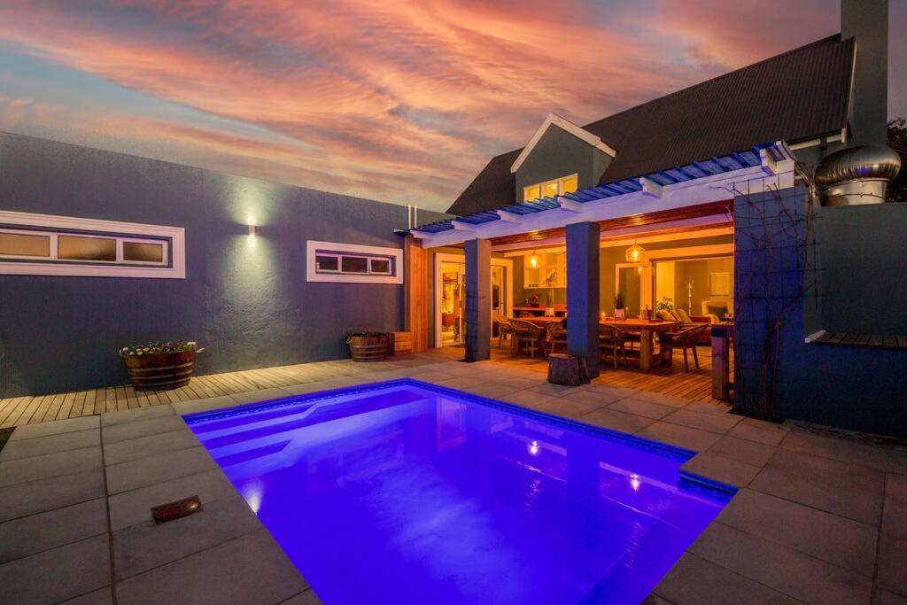 a swimming pool in front of a house at House w Pool, Fireplace, Braai in Cape Town
