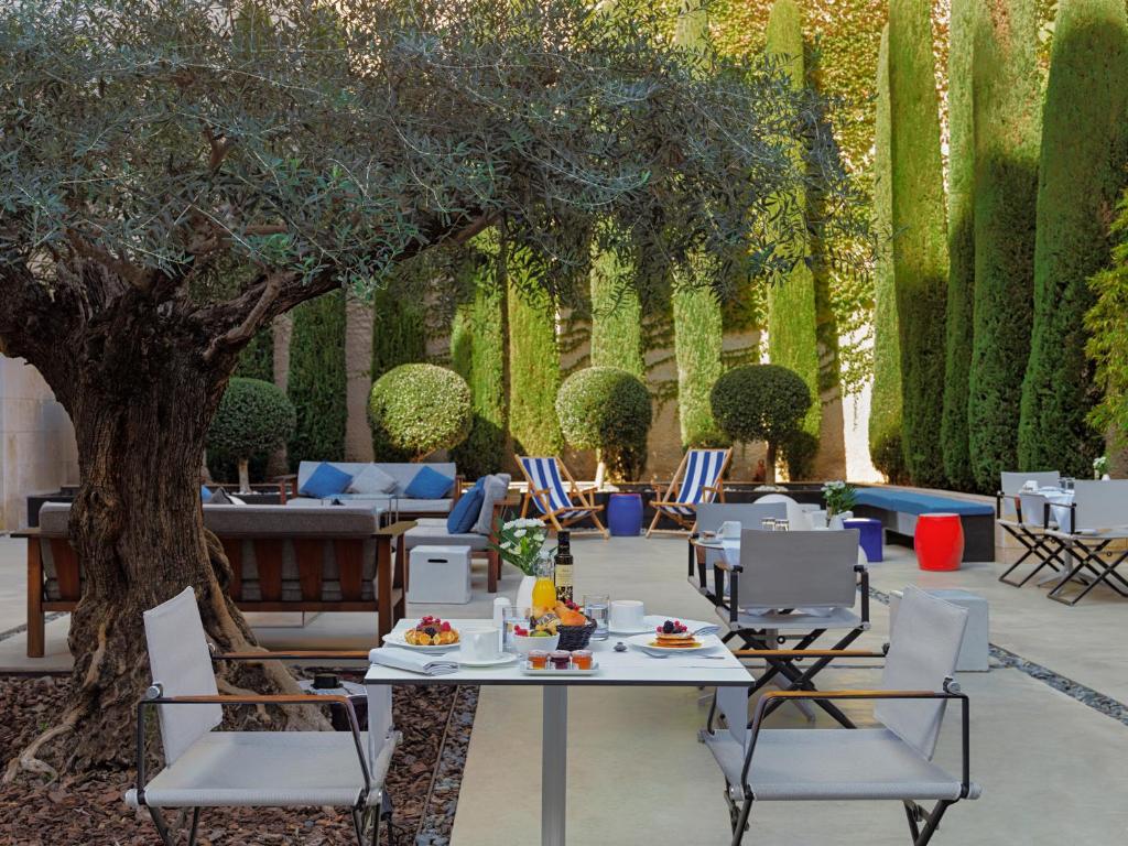 a patio with a table and chairs and a tree at H10 Art Gallery 4* Sup in Barcelona