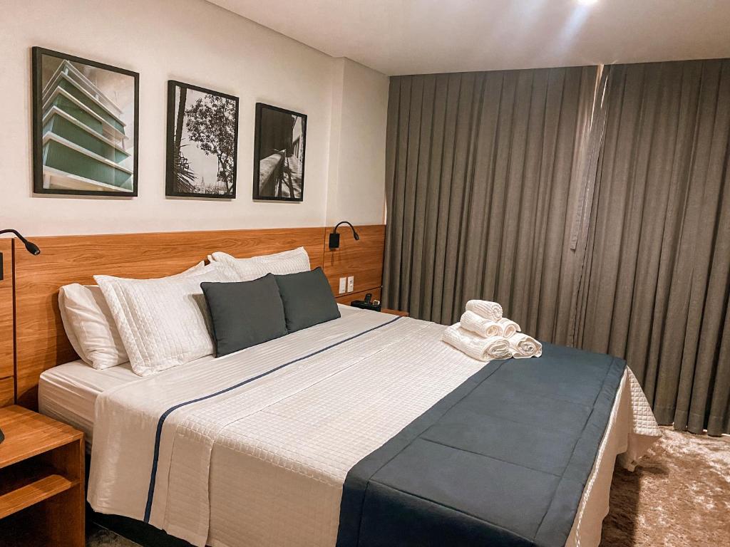 a bedroom with a large bed and a window at Apart-hotel Granja Brasil Itaipava in Itaipava