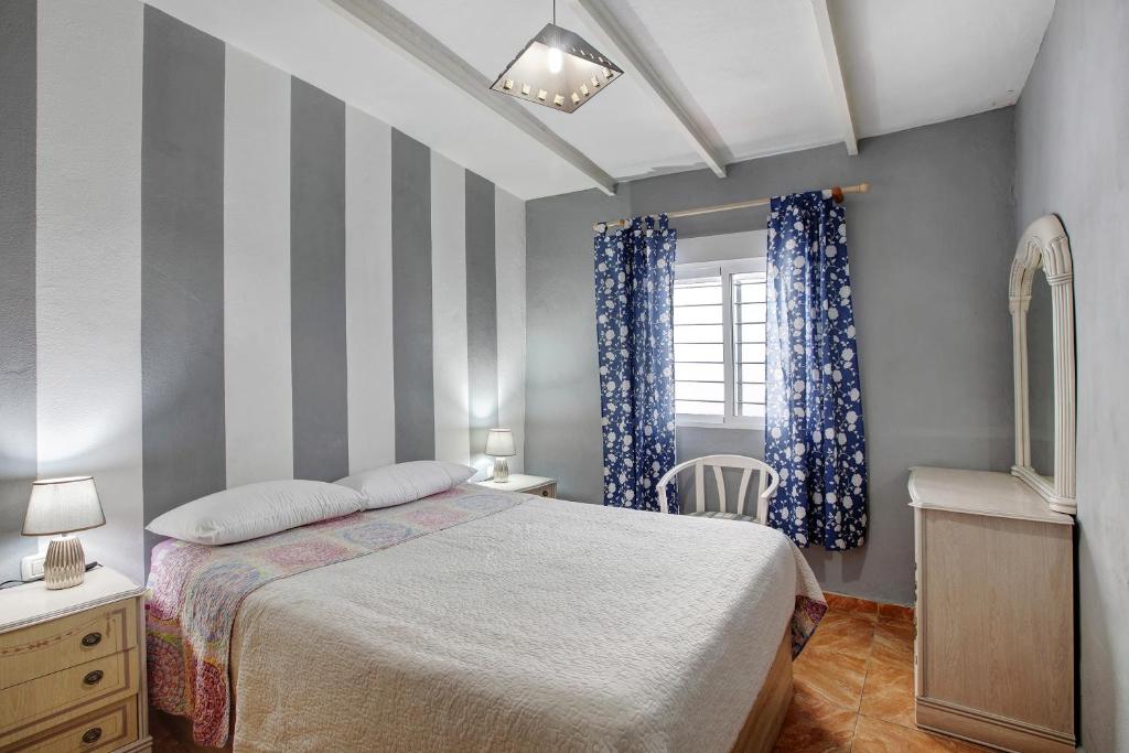 a bedroom with a bed and a striped wall at Casa Marrero Abajo in La Guancha