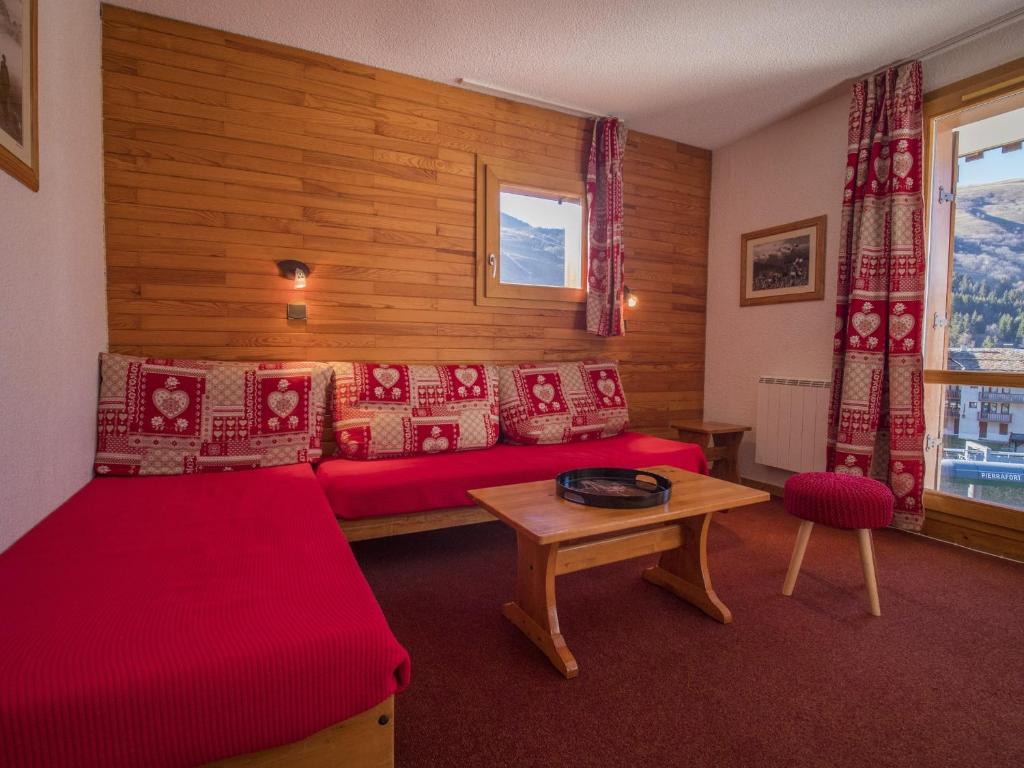 ヴァルモレルにあるAppartement Valmorel, 2 pièces, 5 personnes - FR-1-356-200のベッドルーム(赤いベッド1台、テーブル付)