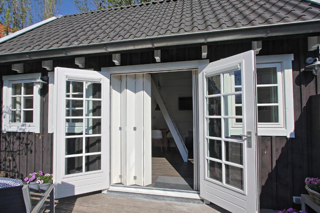 a greenhouse with doors and windows on a deck at Vakantiehuisje Lijsterhofstraat 13 - Baddomburg in Domburg