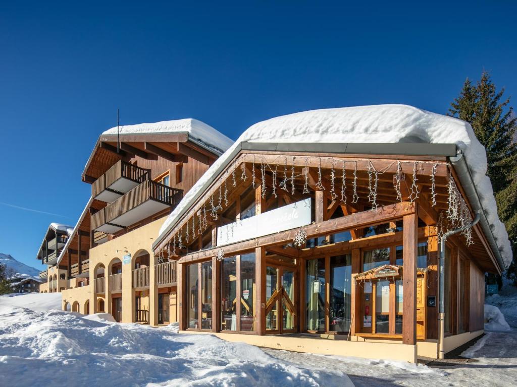 a building covered in snow with icicles hanging from it at Vacancéole - Résidence Le Beauregard in La Léchère