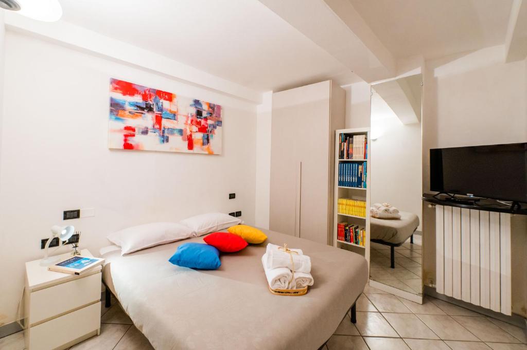 een slaapkamer met een bed en een flatscreen-tv bij FEEL - Minimal House - Bergamo Centro in Bergamo