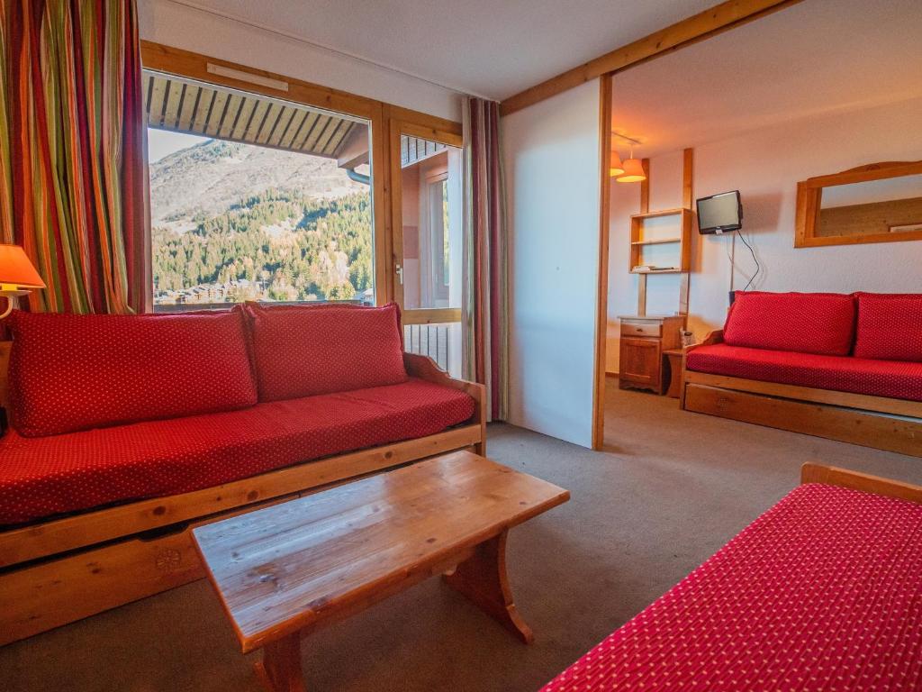 sala de estar con sofá rojo y ventana en Appartement Valmorel, 1 pièce, 4 personnes - FR-1-356-180, en Valmorel