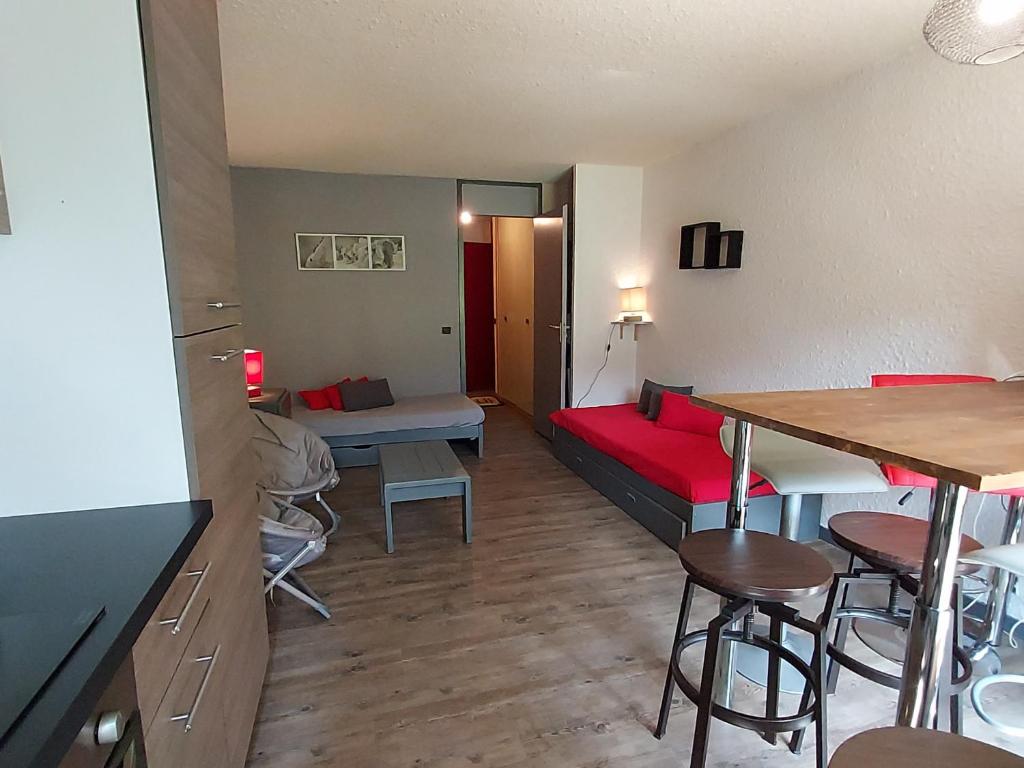 a living room with a red couch and a table at Appartement Valmorel, 2 pièces, 4 personnes - FR-1-356-181 in Valmorel