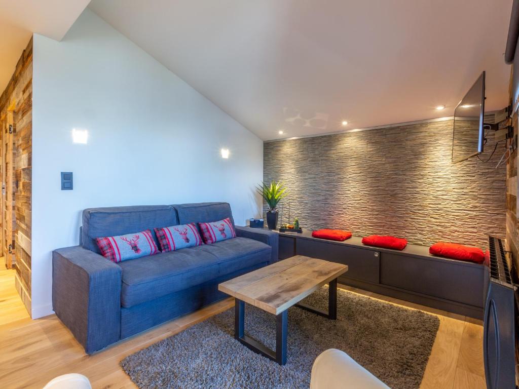 ein Wohnzimmer mit einem blauen Sofa und einem Tisch in der Unterkunft Appartement Valmorel, 3 pièces, 6 personnes - FR-1-356-223 in Valmorel