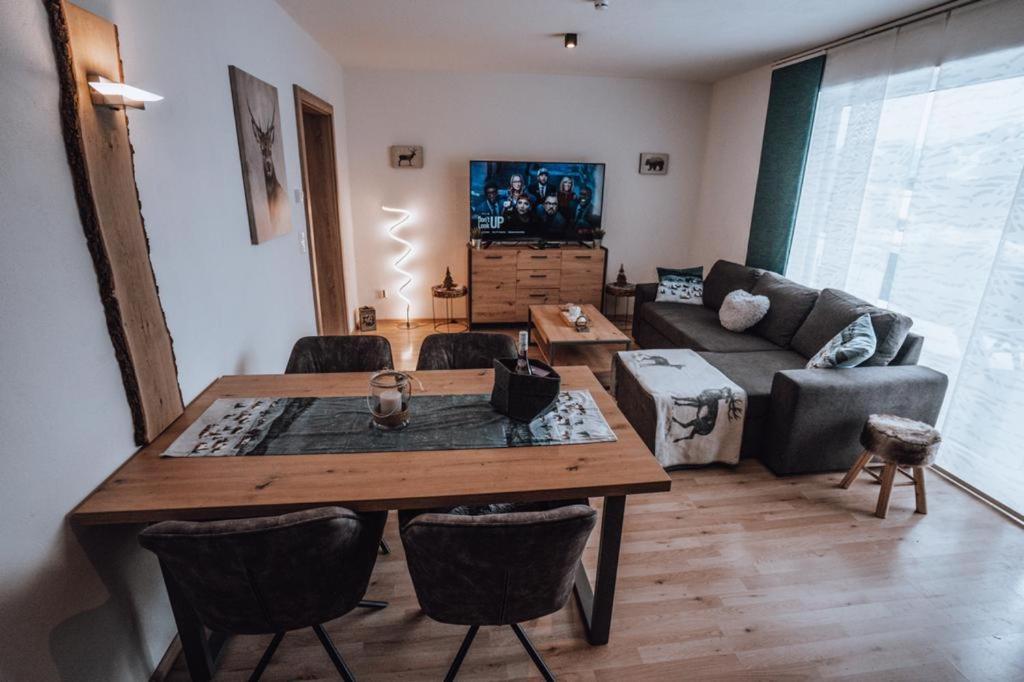 a living room with a table and a couch at Haus Bergzauber in Ramsau am Dachstein