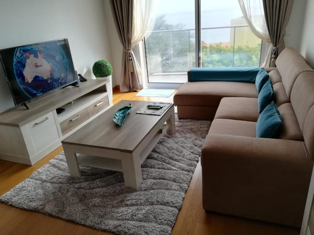 uma sala de estar com um sofá e uma mesa de centro em Tamariz Flat em Santa Cruz