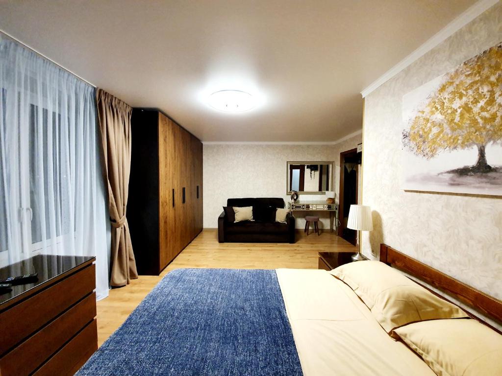モスクワにあるАпартаменты на Цандераのベッドルーム1室(ベッド1台、ソファ付)