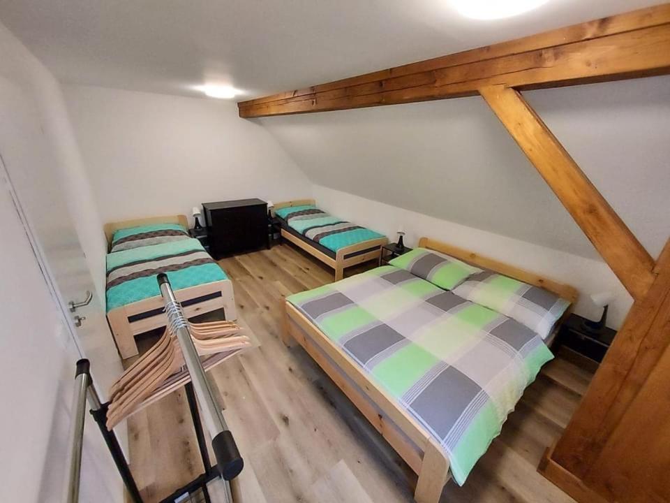 two beds in a room with wooden floors at Apartmány Rudník Bolkov in Rudník