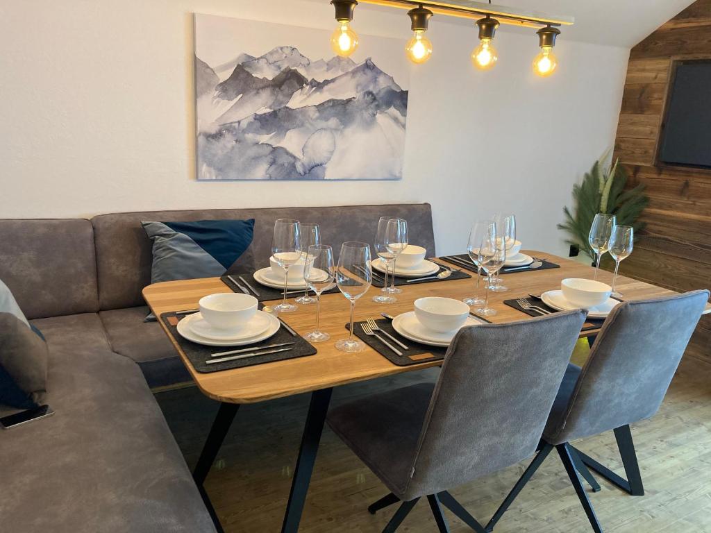 a dining room table with chairs and wine glasses at Haus Angermann in Mallnitz