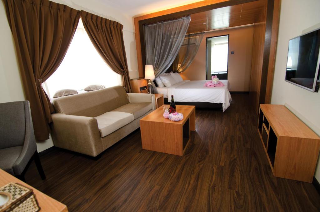 una camera d'albergo con un letto e un divano di C'haya Hotel a Kota Kinabalu