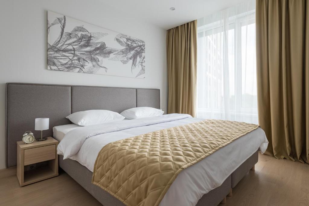 - une chambre avec un grand lit et une grande fenêtre dans l'établissement Apart-hotel YE'S Botanica, à Moscou