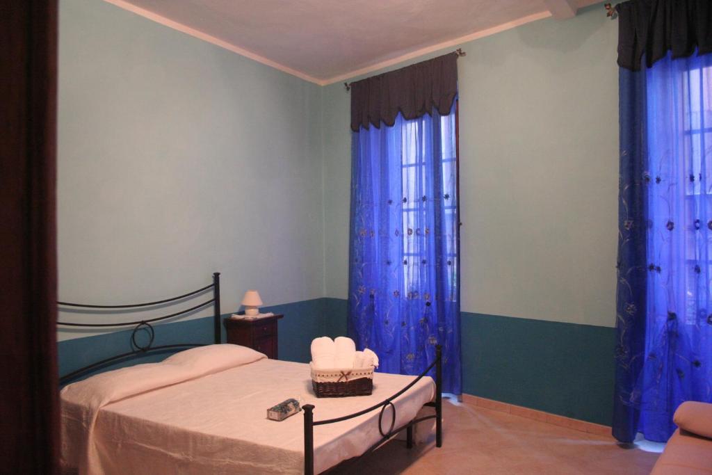 イグレージアスにあるB&B Su Maimoniのベッドルーム(ベッド1台、青いカーテン付)