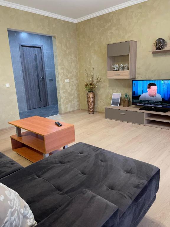 a living room with a couch and a tv at Evro Lux 3 комнаты in Kherson
