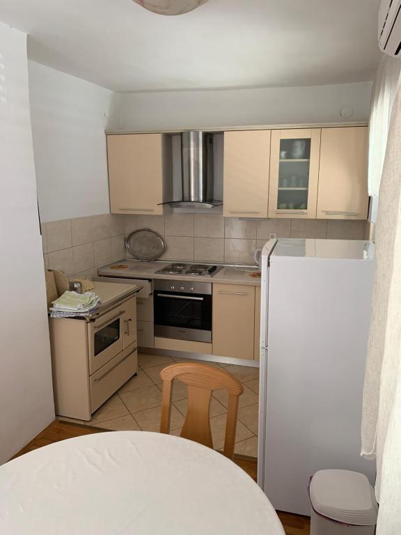 a kitchen with a stove and a chair in it at Apartment Ivanka in Senj
