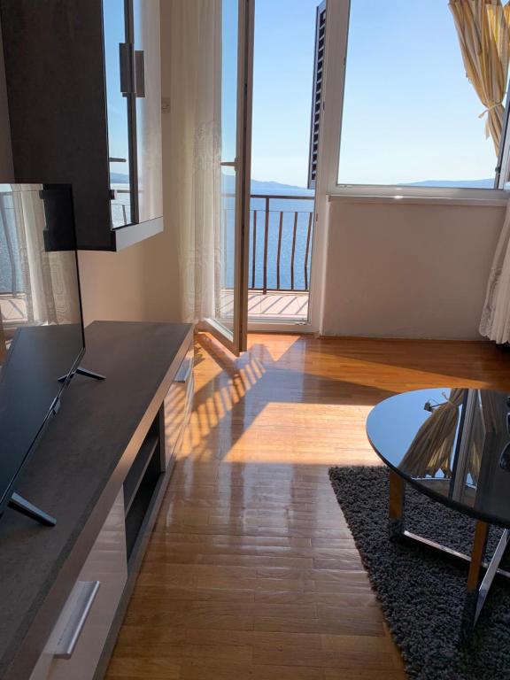 a living room with a table and a large window at Apartment Ivanka in Senj
