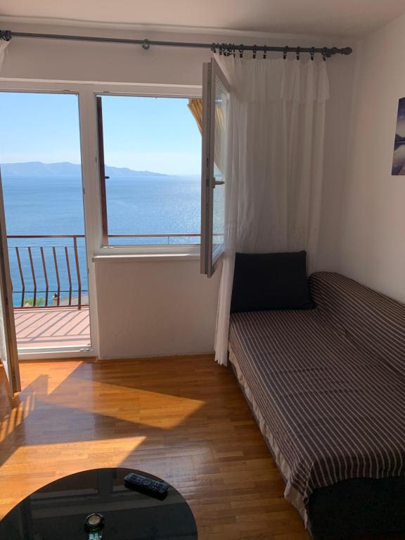 a living room with a couch and a large window at Apartment Ivanka in Senj