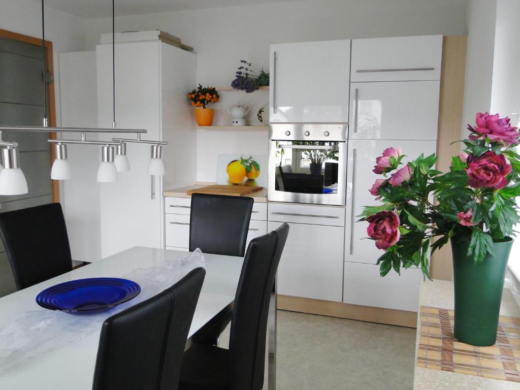 una cocina con una mesa con un jarrón de flores en Ferienwohnungen Steinhof-Littmann, en Kippenheim