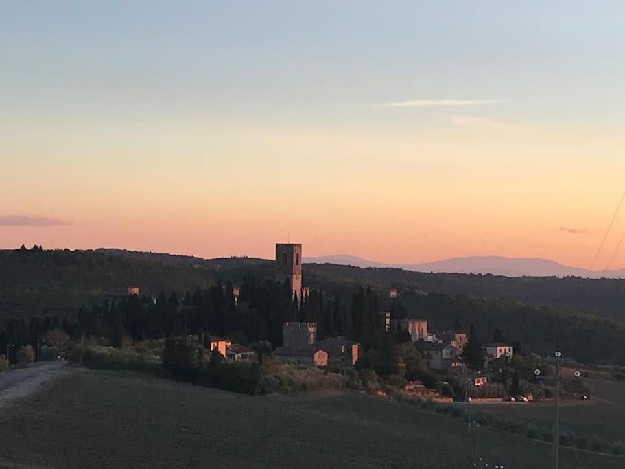 a town on a hill at sunset with a tower at Il Fiorino di Badia in Badia A Passignano