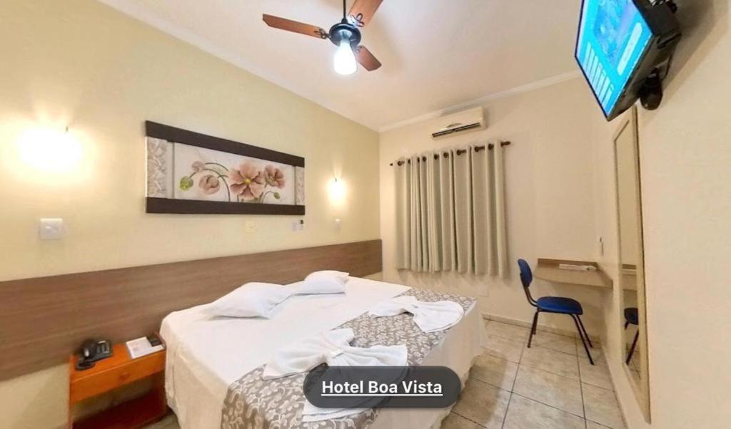 a hotel room with a bed and a tv at Hotel Boa Vista in Americana