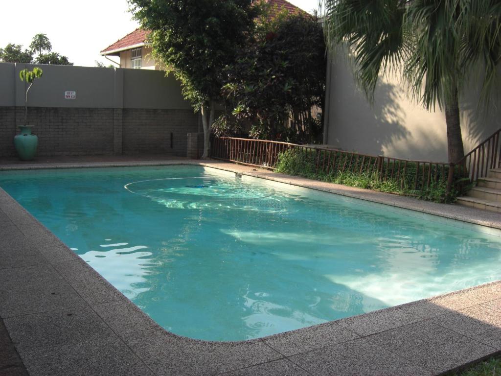 una piscina de agua azul frente a un edificio en The Deck on Manning, en Durban