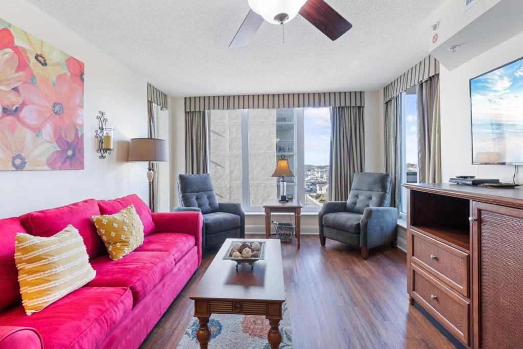 a living room with a red couch and chairs at Ocean View Bahama Sands Stunning Resort in Myrtle Beach