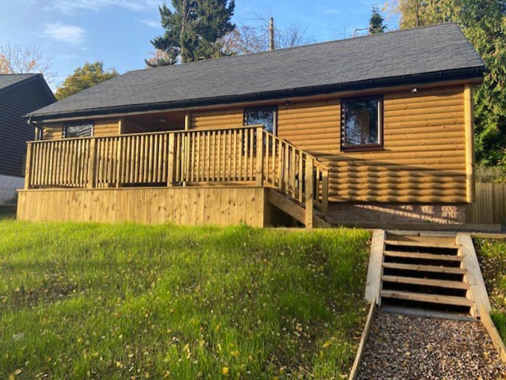 a log cabin with a staircase in front of a house at Immaculate 3 bed lodge in Blairgowrie in Blairgowrie