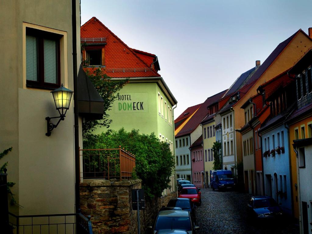 a narrow alley with buildings and cars parked on a street at Hotel Dom-Eck in Bautzen