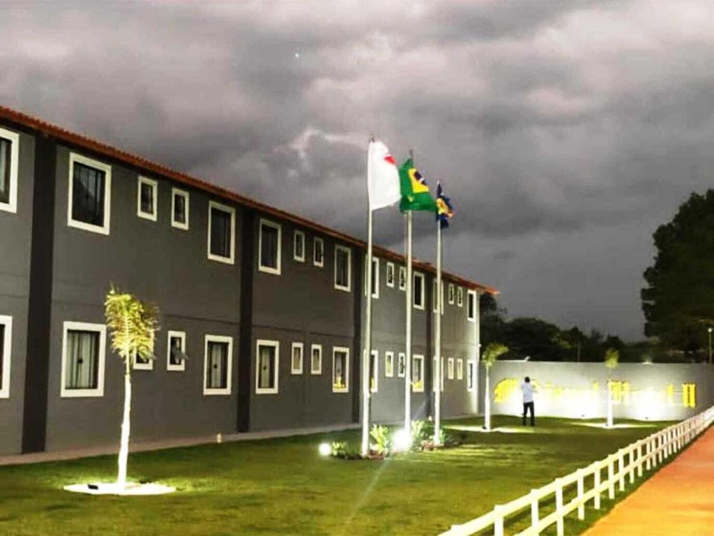 a building with two flags in front of it at MEDIEVAL HOTEL II in Três Corações