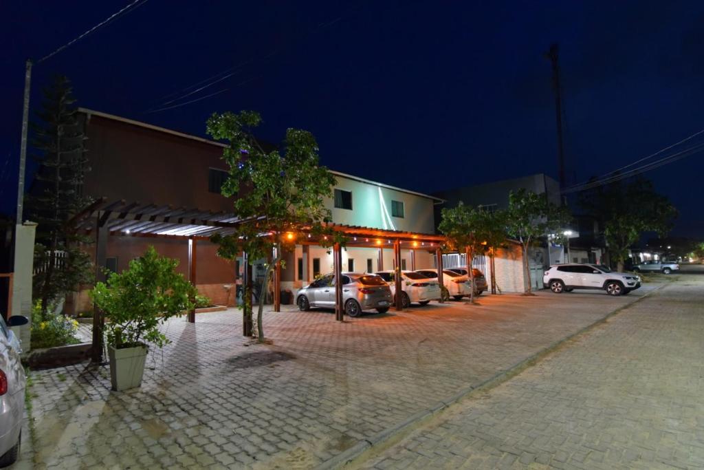 un estacionamiento con autos estacionados frente a un edificio en Pousada Paraíso dos Lençóis, en Barreirinhas