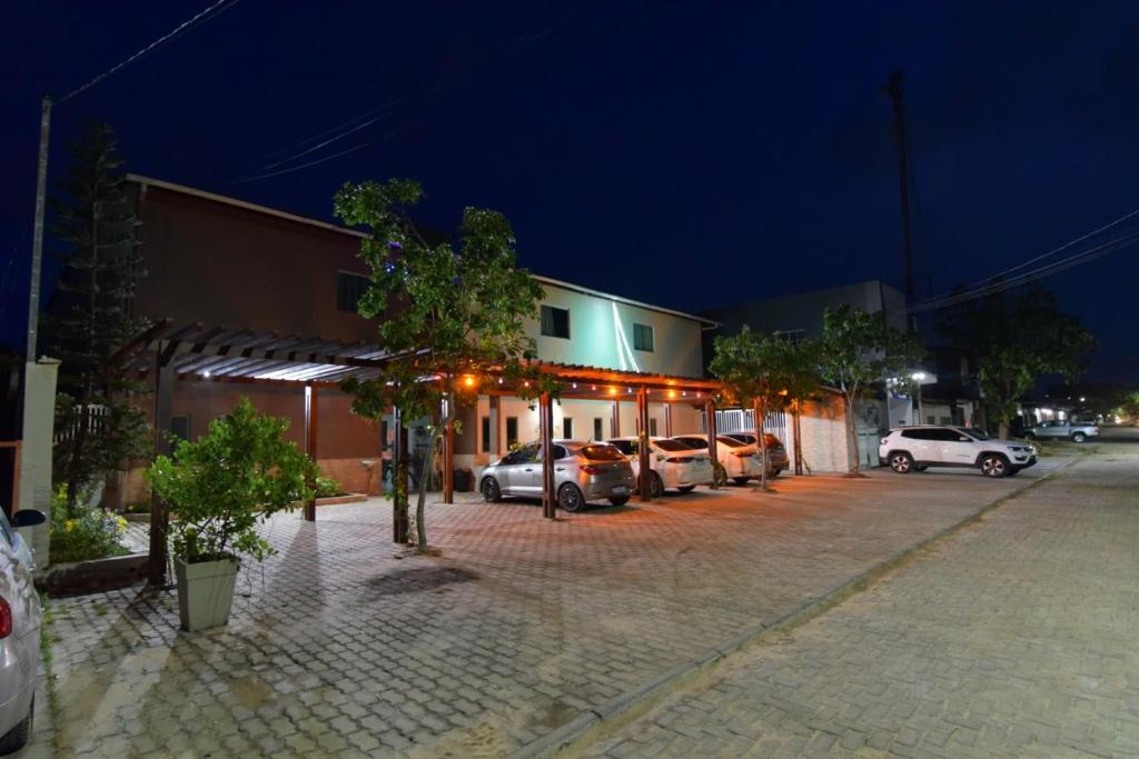 a parking lot with cars parked in front of a building at Pousada Paraíso dos Lençóis in Barreirinhas