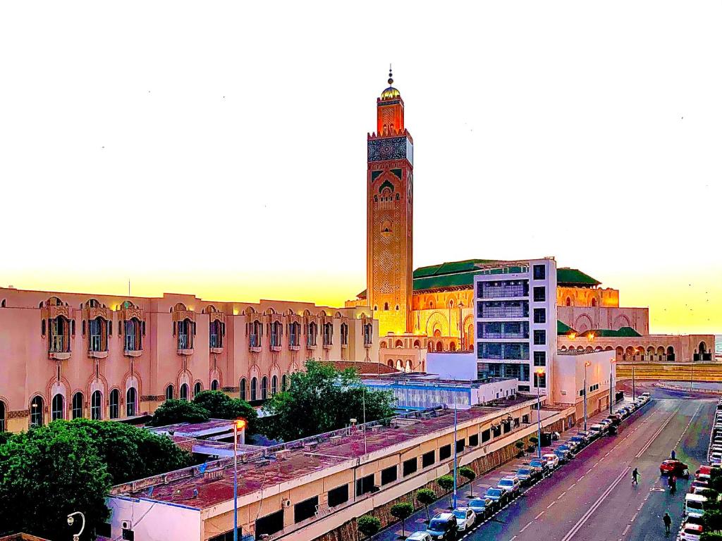a city with a clock tower and a street with cars at Sab 9 - Great View Over Hassan Mosque. Luxurious 3 Bedrooms & 2,5 Bathrooms in Casablanca