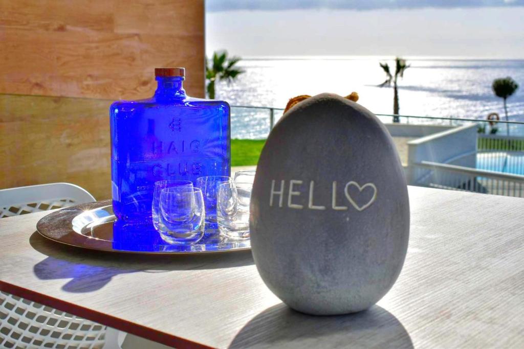 a blue bottle sitting on a table with glasses at SUNNY BEACH APARTMENT IN CALACEITE in Torrox Costa