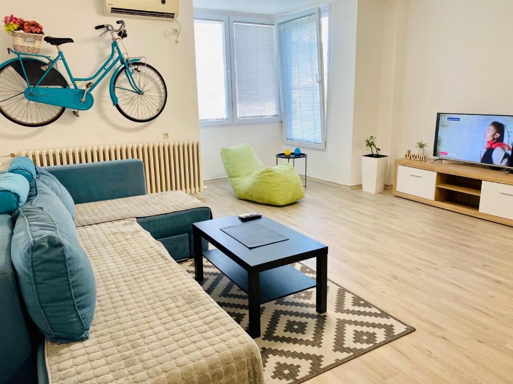sala de estar con sofá y bicicleta en la pared en Regina's Modern Apartment2, en Skopje