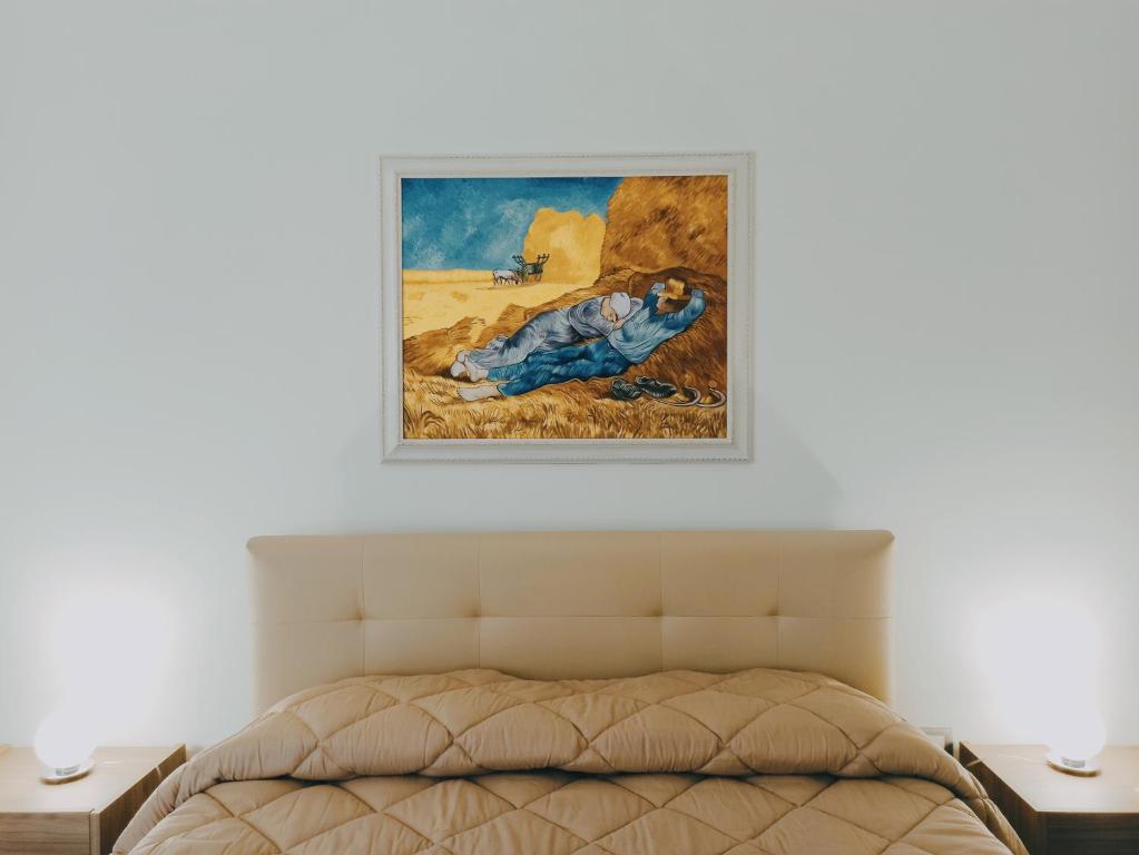 uma pintura acima de uma cama num quarto em Bed&Book 'A parma em Salemi