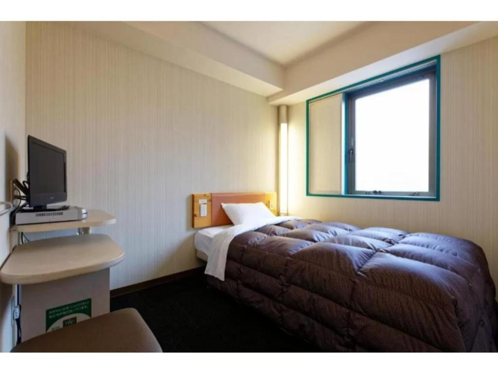 Habitación de hotel con cama y TV en R&B Hotel Kumamoto Shimotori - Vacation STAY 39080v, en Kumamoto