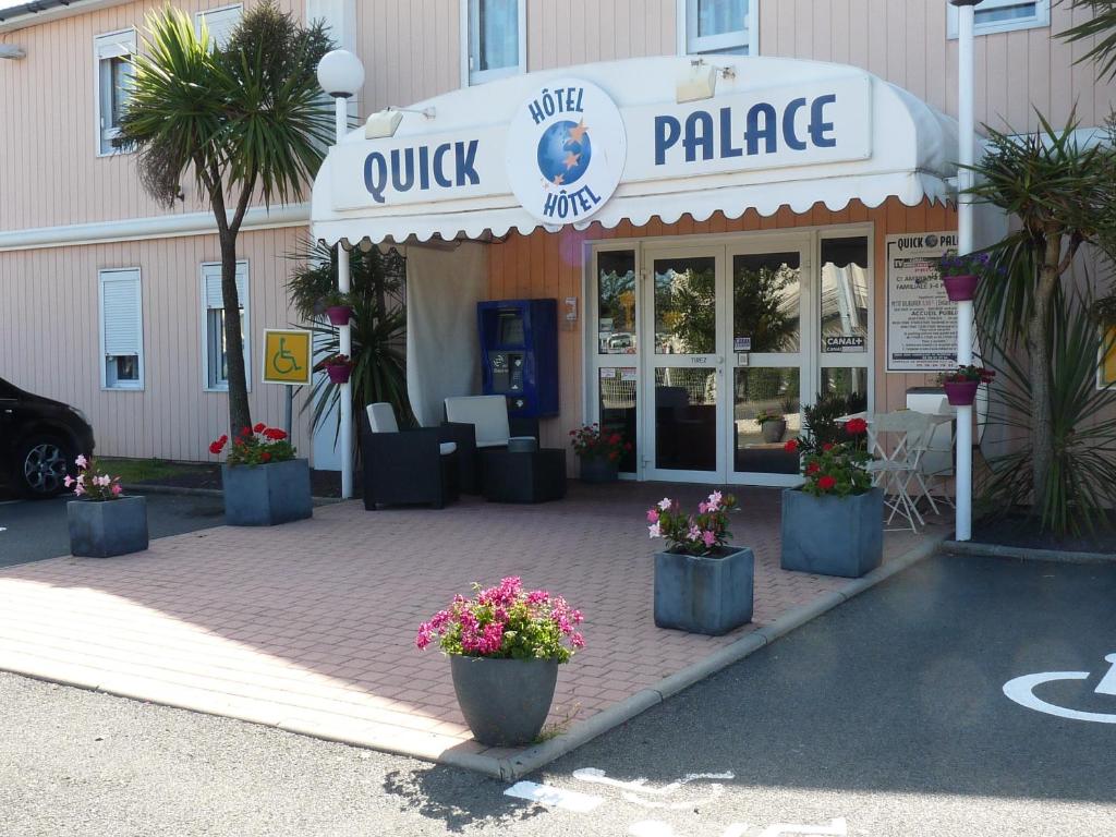 a store with potted plants in front of a building at Quick Palace Saint Brieuc in Tregueux