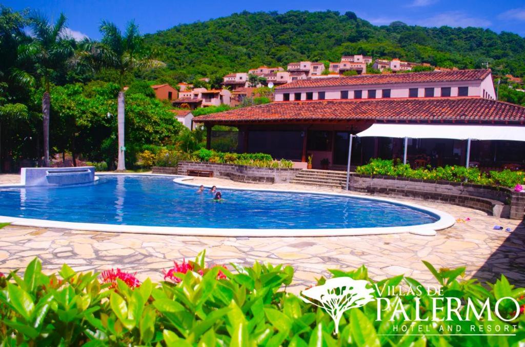 a swimming pool in the middle of a resort at Villas de Palermo Hotel and Resort in San Juan del Sur