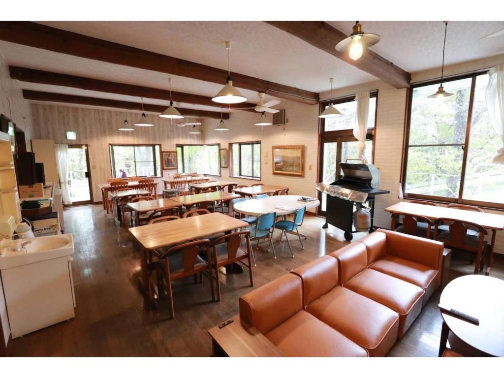 um restaurante com mesas e cadeiras e um piano em clubhouse atelier - Vacation STAY 05548v em Shiozawa