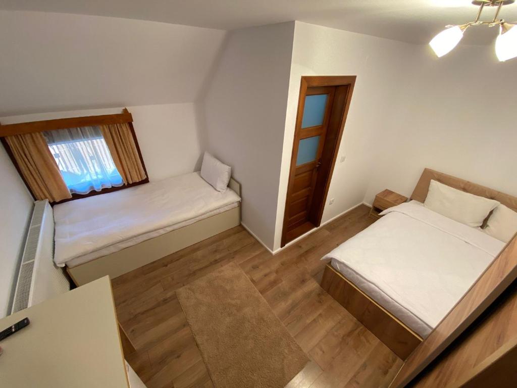 a small room with two beds and a window at Casa Mocanu in Sărmaş